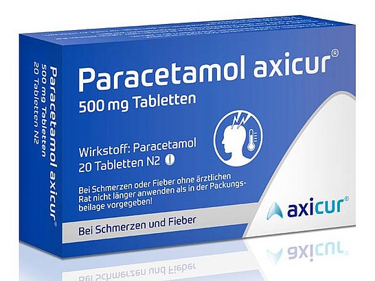 Eine blau-weiße Schachtel Paracetamol axicur Tabletten, beschriftet mit 500 mg. Sie enthält 20 Tabletten und zeigt das Symbol einer Person mit Kopfschmerzen. Der Text ist auf Deutsch und erwähnt die Verwendung gegen Schmerzen und Fieber. Unten rechts befindet sich das Markenlogo „axicur“.